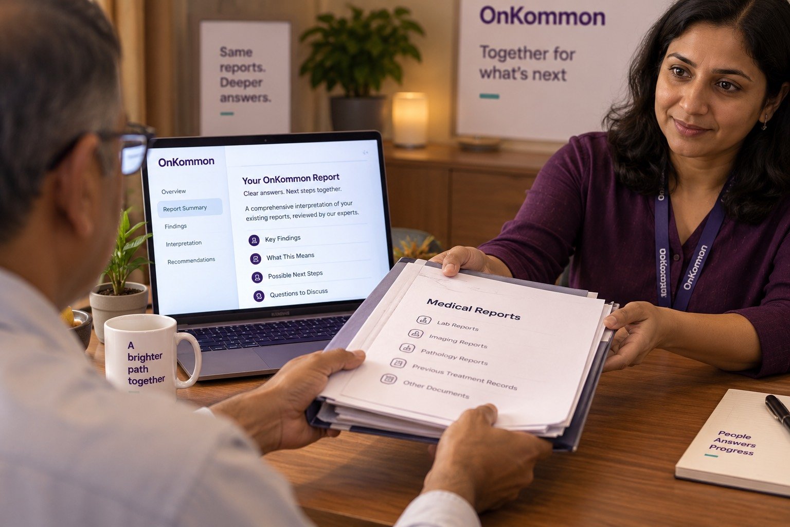 A patient handing a folder of previous laboratory reports across a desk, with an OnKommon report open on a laptop beside them.